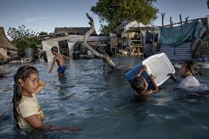 Niños rescatando sus objetos personales tras una inundación