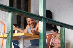 Un hombre sonriendo en la terraza junto a su mujer