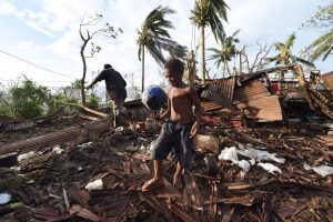 Un niño juega sobre las ruinas de su hogar tras el paso del ciclón Pam, en Vanuatu