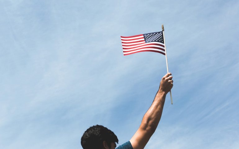 inmigrante sosteniendo la bandera de Estados Unidos