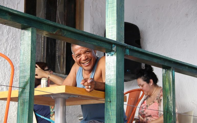 Un hombre sonriendo en la terraza junto a su mujer